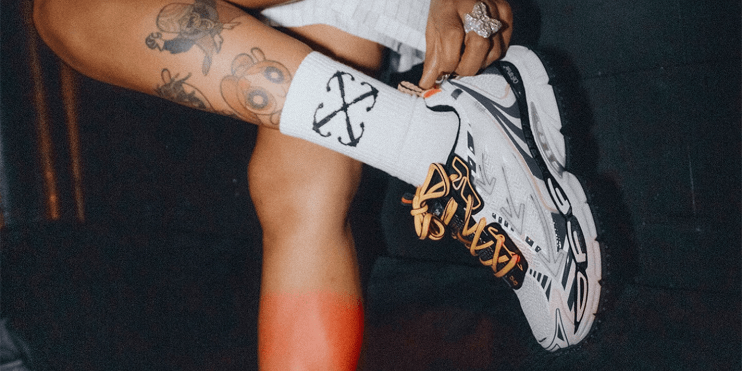 white off-white sneakers with yellow laces on feet